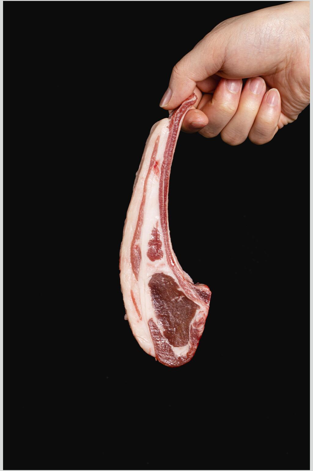 手拿生肉牛排摆拍摄影图素材