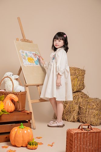 秋季白色碎花连衣裙儿童画画人物摄影图片