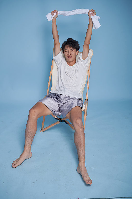 夏季男生泳衣泳装运动坐沙滩椅摄影图