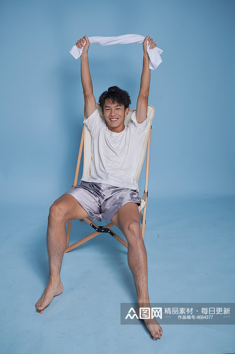 夏季男生泳衣泳装运动坐沙滩椅摄影图素材