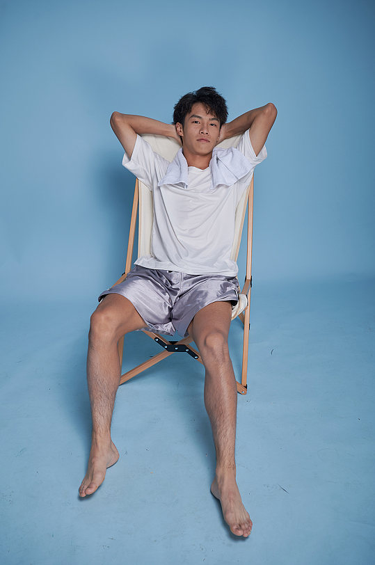 夏季男生泳衣泳装运动坐沙滩椅摄影图