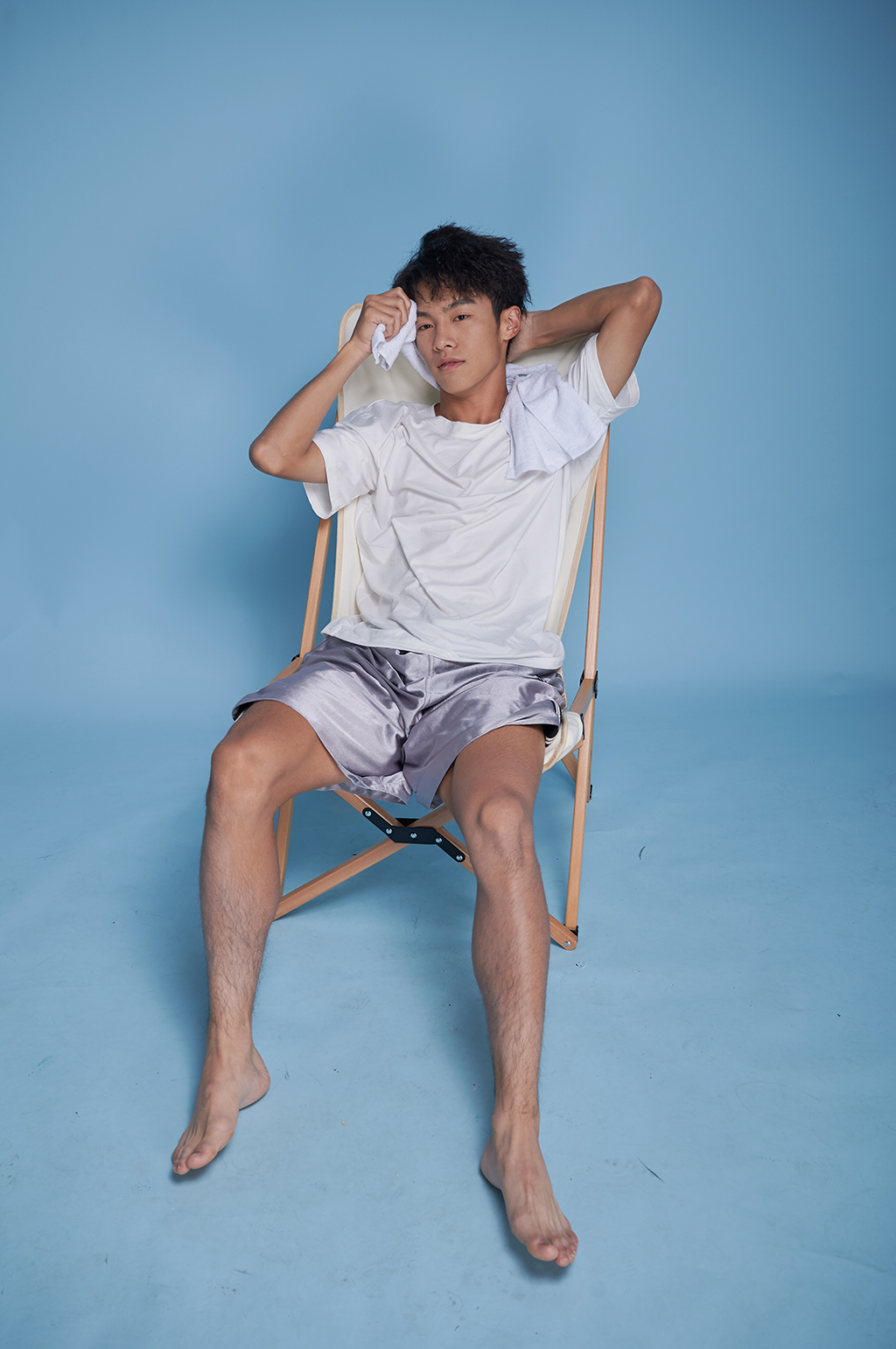 夏季男生泳衣泳装坐沙滩椅摄影图素材