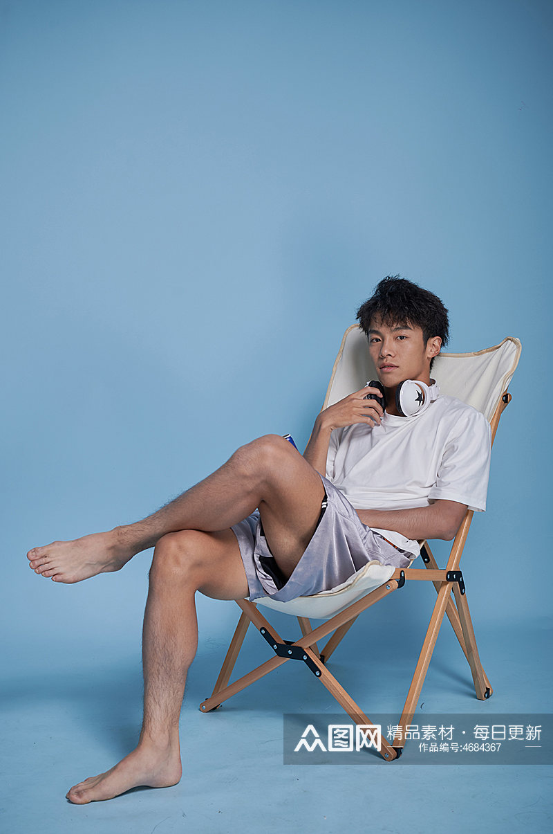 夏季男生听歌泳装坐沙滩椅摄影图素材