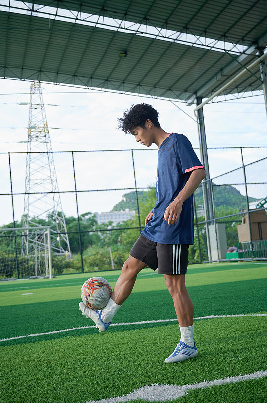 体育运动男生踢足球健身人物摄影图
