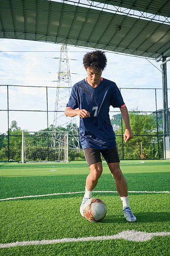 体育运动男生踢足球健身人物摄影图