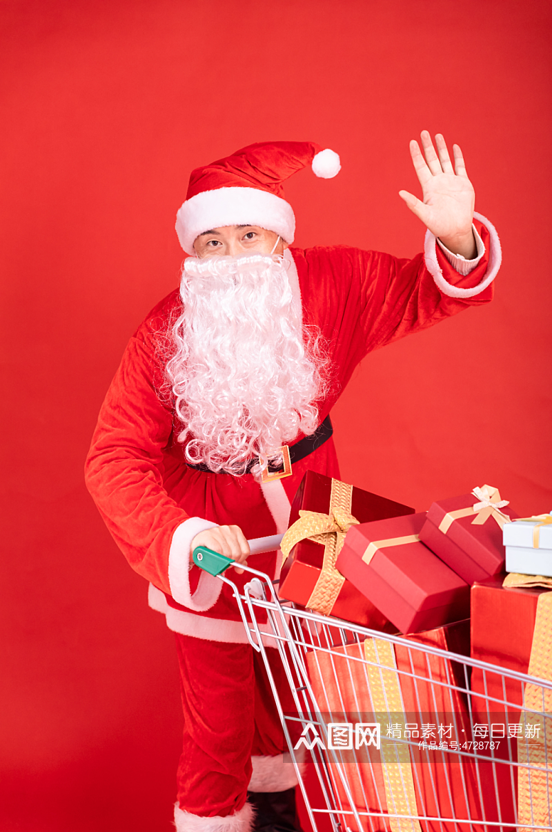 红色背景上推着购物车的圣诞老人摄影图素材