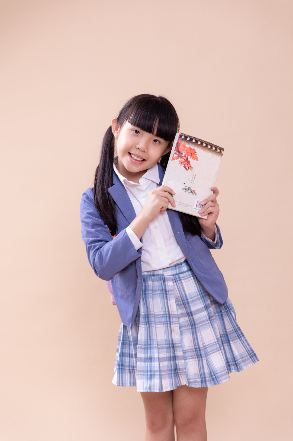 拿着书的可爱小学生摄影图素材