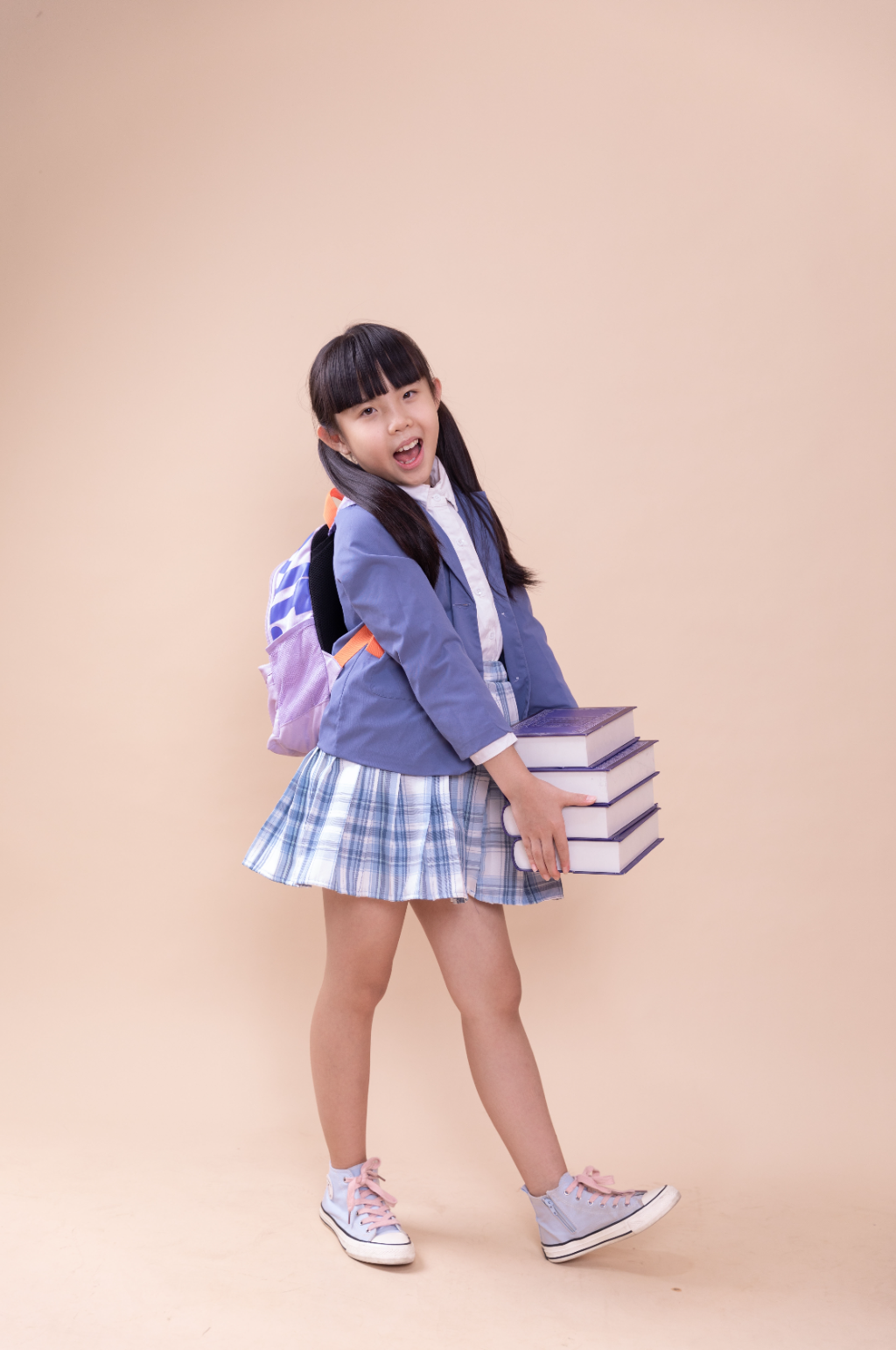 抱着一摞书的小学生小女孩摄影图素材