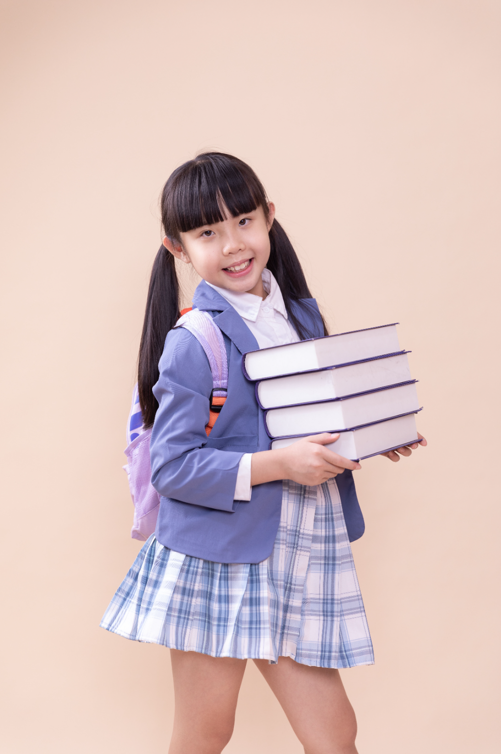 抱着一摞书的小学生小女孩摄影图素材