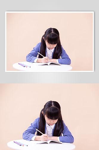 低头写作业的小学生小女孩摄影图