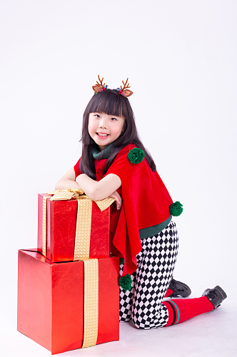 趴在礼物盒上的可爱的圣诞小女孩摄影图