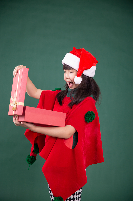 抱着礼物盒的圣诞小女孩摄影图