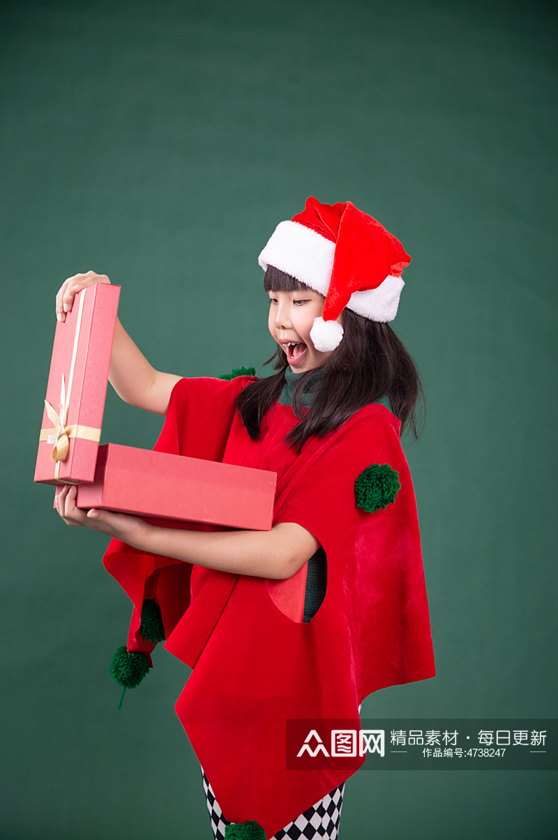 抱着礼物盒的圣诞小女孩摄影图素材