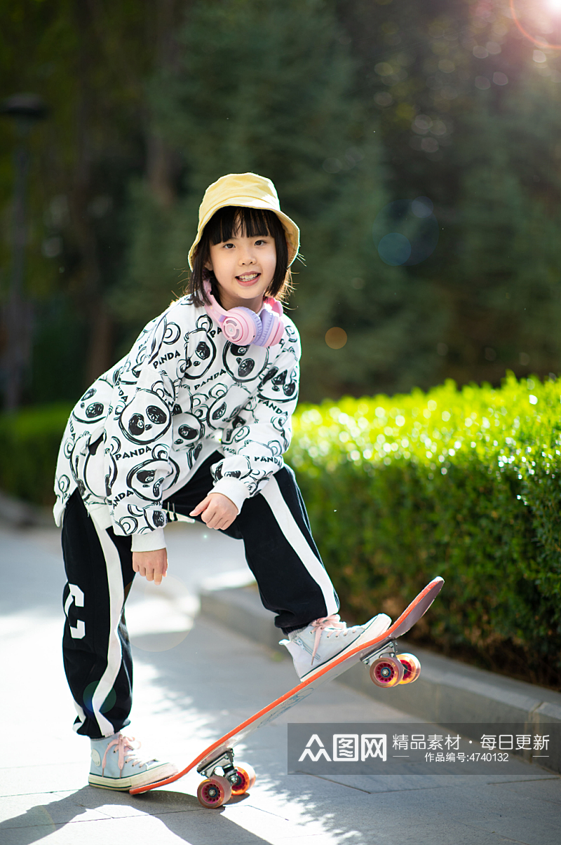 户外玩滑板的小女孩素材