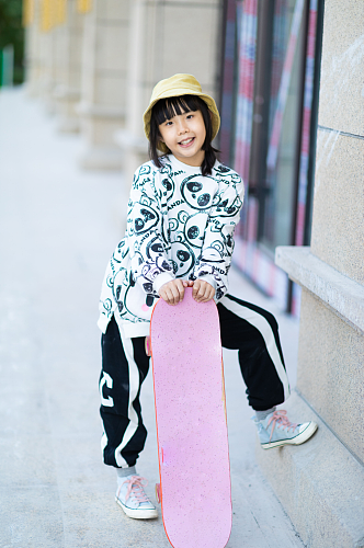 户外玩滑板的小女孩