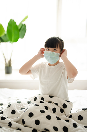 坐在床上戴口罩发烧感冒小女孩春季流感人物摄影图