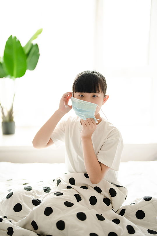坐在床上戴口罩小女孩春季流感感冒人物摄影图