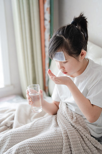 端着水杯发烧感冒吃药小女孩春季流感人物摄影图