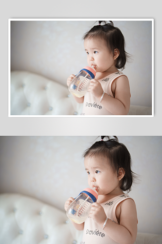 抱着奶瓶喝奶的婴儿摄影图