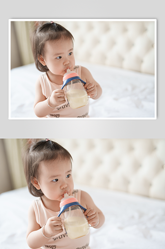 坐在床上喝奶的婴儿人物摄影图