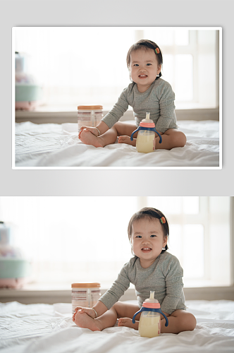 坐在床上喝奶粉的小宝宝人物摄影图