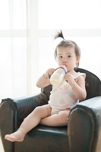 坐在沙发上喝奶的人物摄影图片