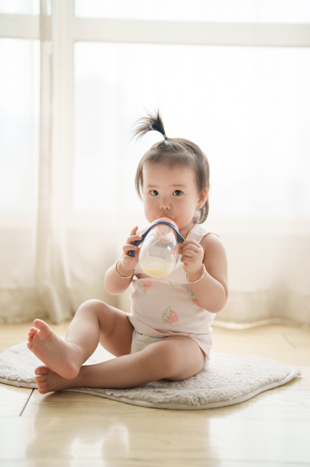 穿着背心喝奶的可爱婴幼儿摄影图素材