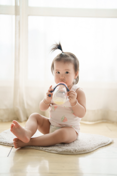 穿着背心喝奶的可爱婴幼儿摄影图