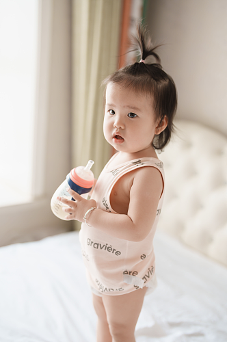 站在床上喝奶粉的小宝宝人物摄影图