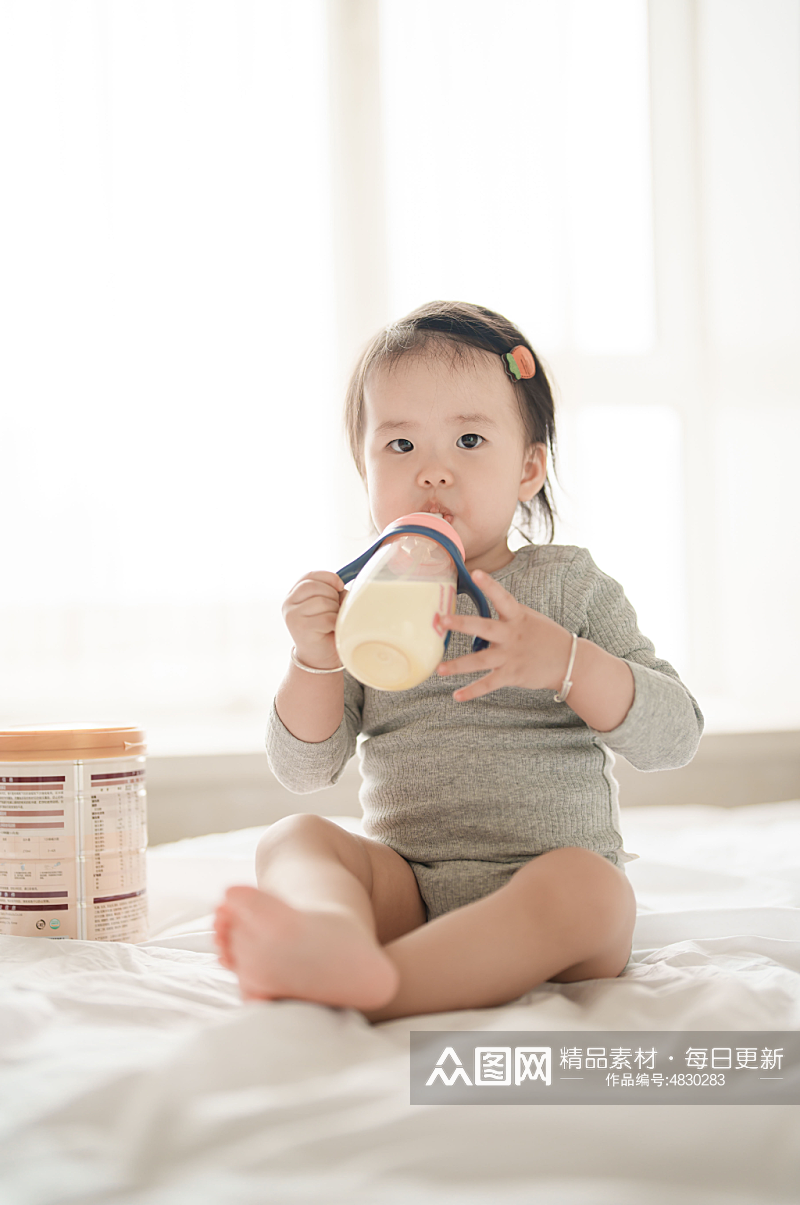 坐在床上喝奶粉的小宝宝人物摄影图素材