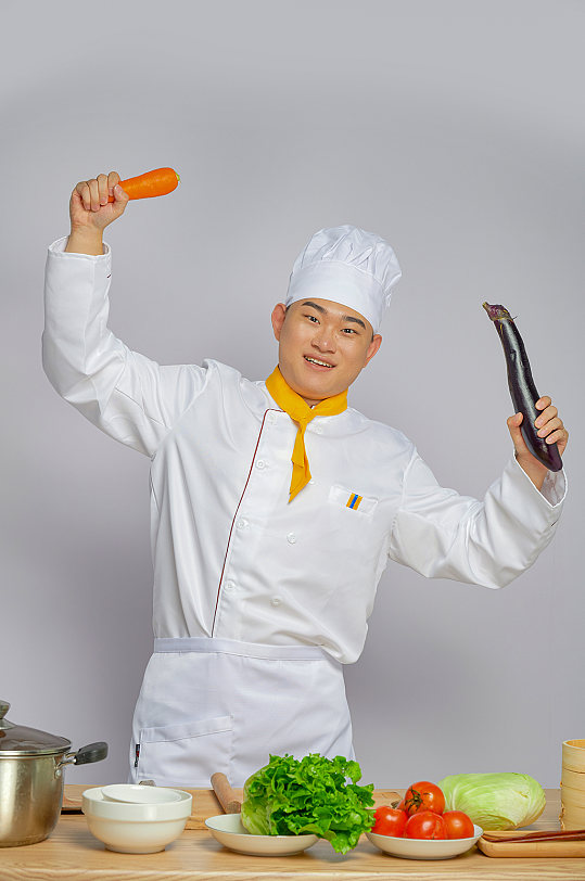 餐饮职场厨师服人物拿茄子胡萝卜摄影图片