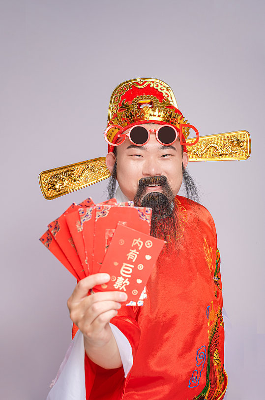 喜庆财神爷拿红包人物摄影图片