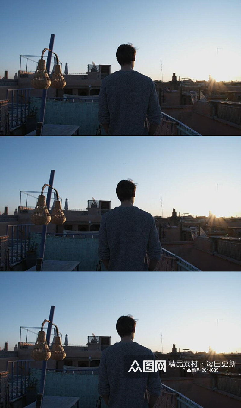 男人走在屋顶上看清晨日出实拍素材