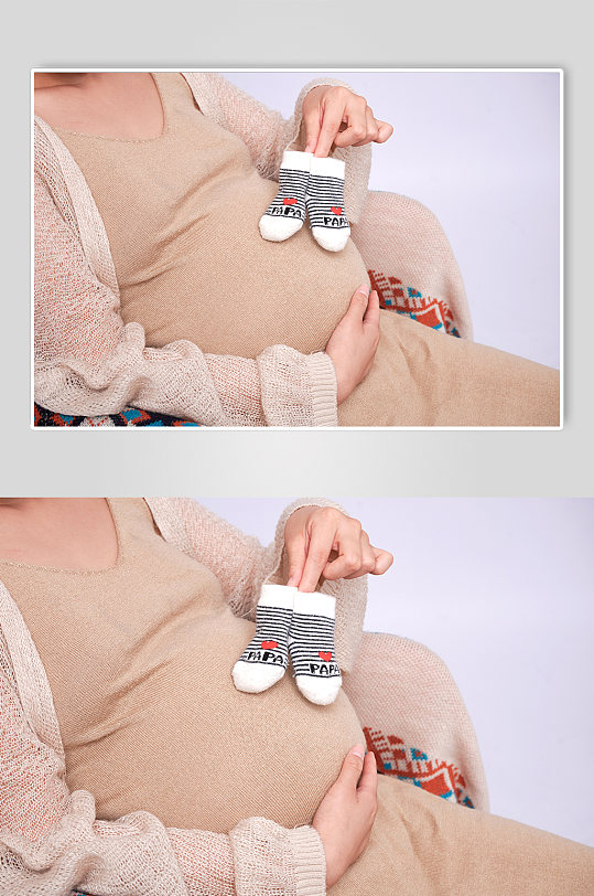 手拿婴儿袜优雅孕妇人物摄影图