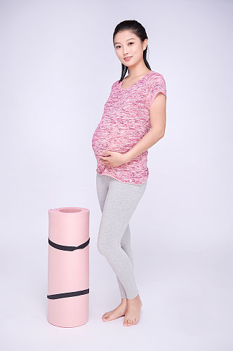 瑜伽垫手扶肚子孕妇瑜伽人物摄影图