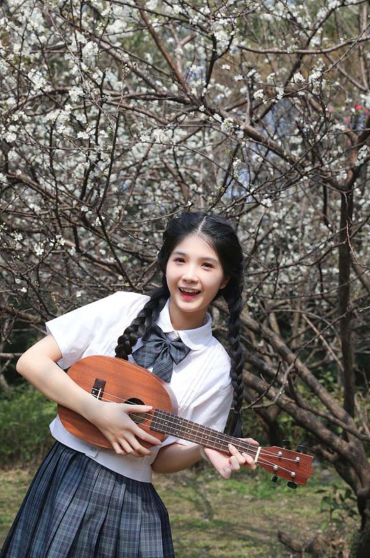 清新少女弹琴校服赏花季樱花人物摄影图片-众图网