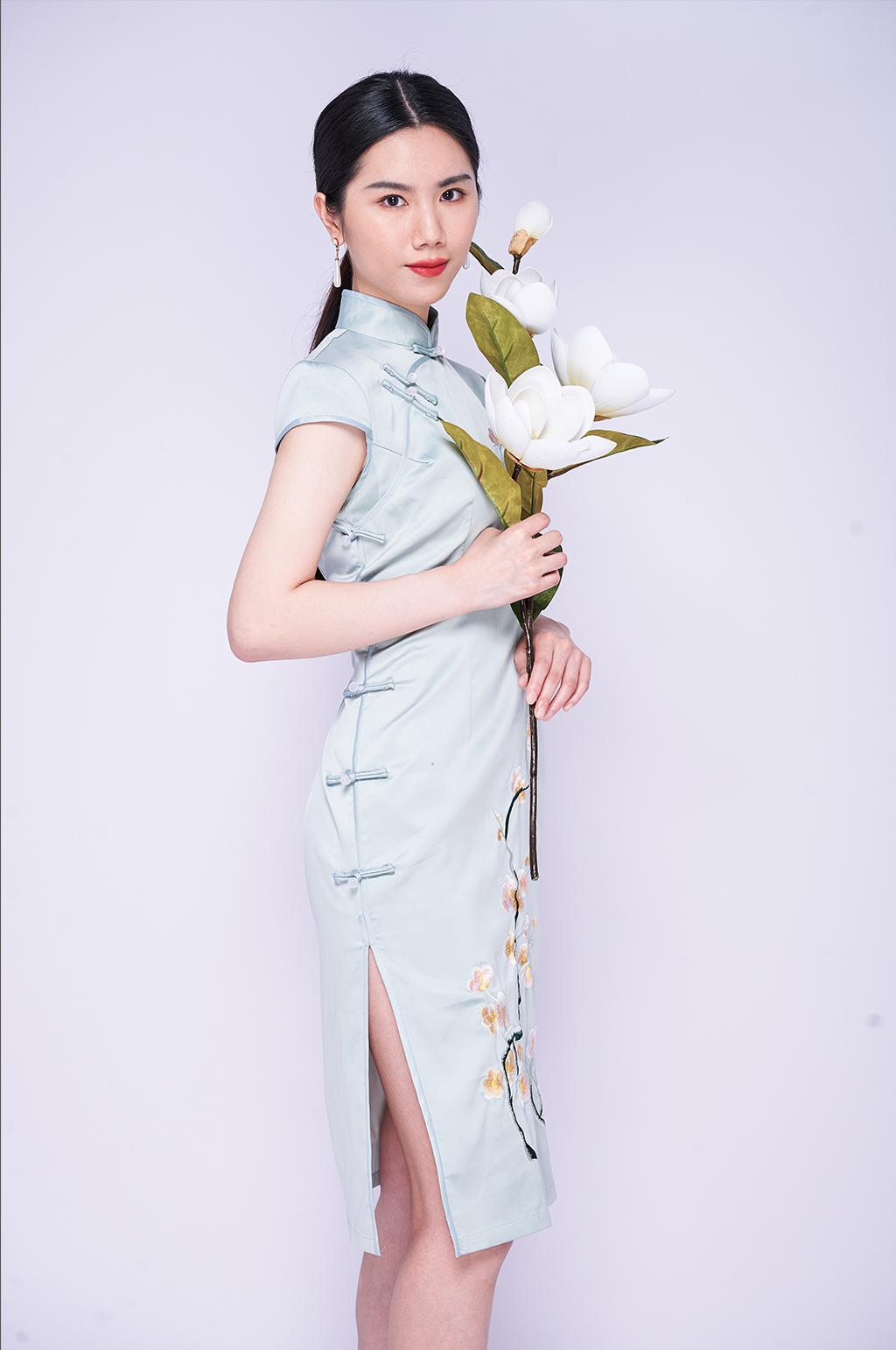 美丽优雅旗袍女青年手捧鲜花商业摄影图片素材