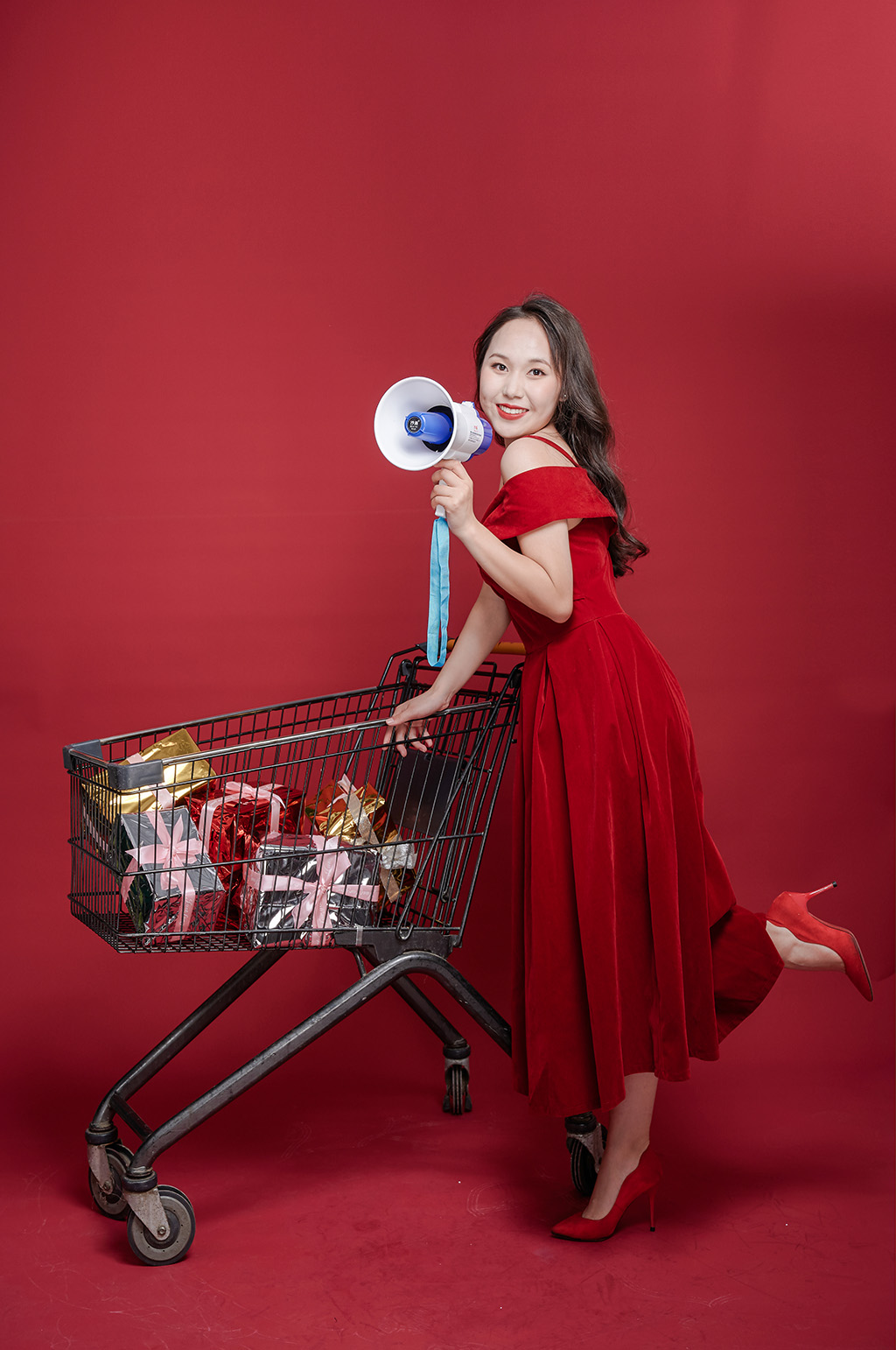 红裙女性手持喇叭商场新年大促购物摄影图素材