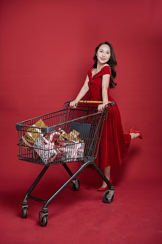 喜庆红裙女生新年推购物车购物人物摄影图