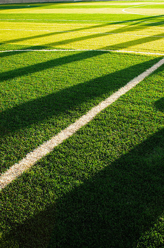 晚霞光绿色草地对角白线足球场摄影图照片
