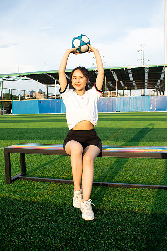 女生单人举球草地足球运动场人物摄影图照片