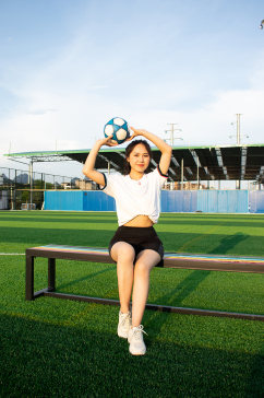 女生单人举球足球运动场人物摄影图照片