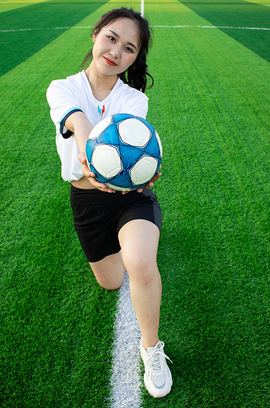 女生单人跪姿足球运动场人物摄影图照片