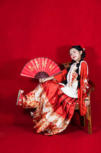红色新年汉服女生折扇坐姿人物PNG摄影图
