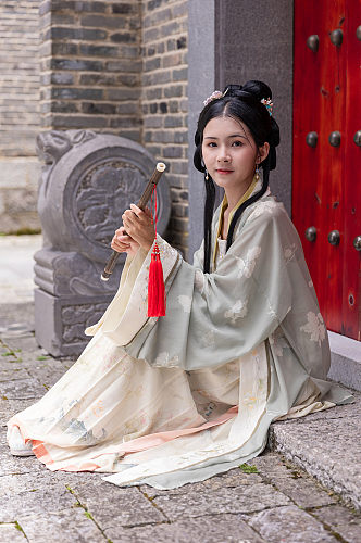 中式古装汉服女性手拿坐姿横笛人物摄影图