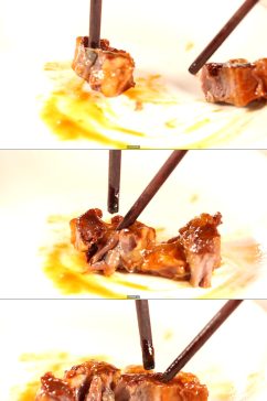 筷子夹起一块红酒牛肉