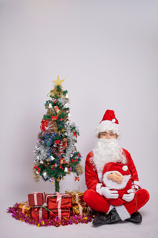 圣诞老人坐着双手抱娃娃人物摄影图