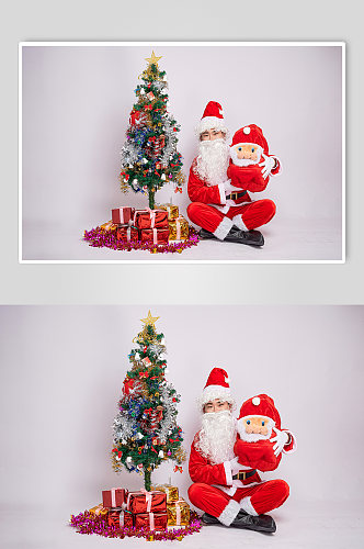 圣诞节圣诞老人坐姿手抱娃娃人物摄影图