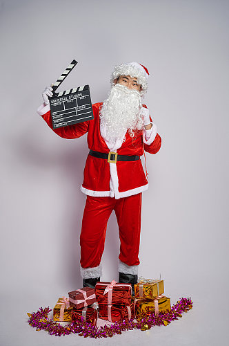 圣诞节圣诞老人背礼物手拿场记板人物摄影图