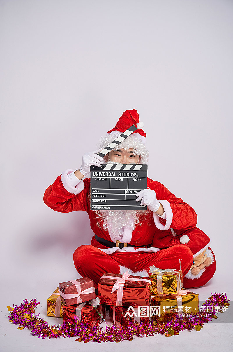 圣诞节圣诞老人坐姿拿场记板人物摄影图素材